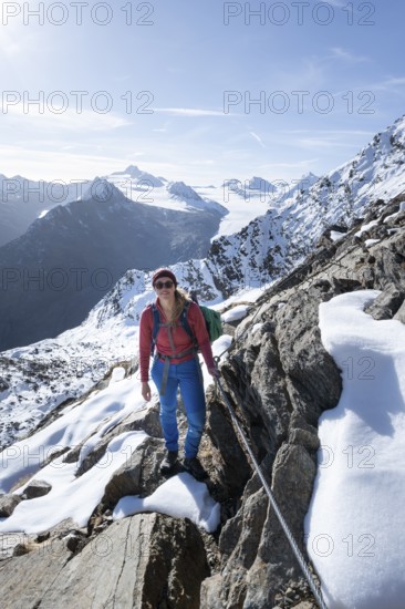 Mountaineer on a secured path with snow, climbing up to Ramoljoch, behind mountain Ramolkogel, Sonnenstern, Ötztal Alps, Tyrol, Austria
