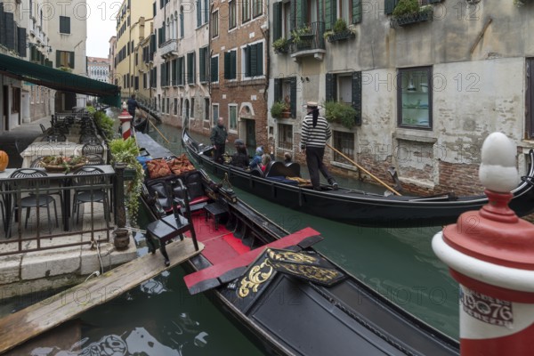 Gondola ride with tourists through the old town of Venice, Veneto, Italy
