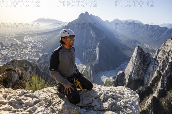A man takes a break after practicing mountaineering and rappelling at Eagle's Nest in Monterrey, Mexico, enjoying the stunning views of the rugged mountainous landscape