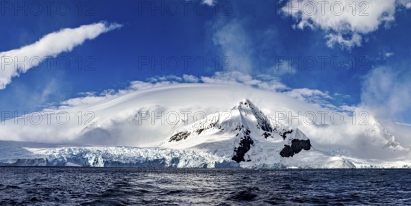 Panoramic view of impressive snow-capped mountains under dramatic clouds, The landscape in the Southern Ocean in Antarctica