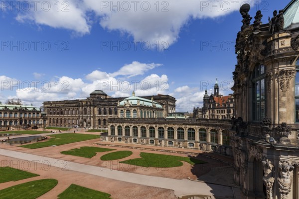 The Zwinger Palace in Dresden, Germany, showcases its stunning baroque architecture under a vibrant blue sky. This historic landmark captivates with its intricate details and elegant design