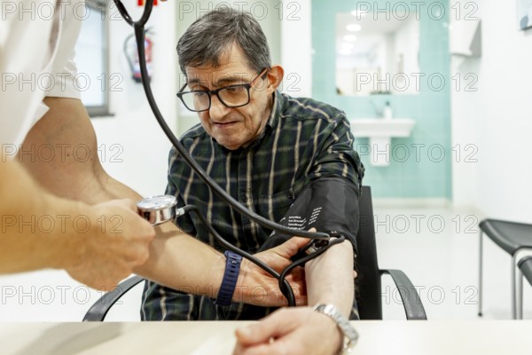 A healthcare professional checks the blood pressure of a resident in a mental health facility, highlighting the importance of regular health monitoring and support