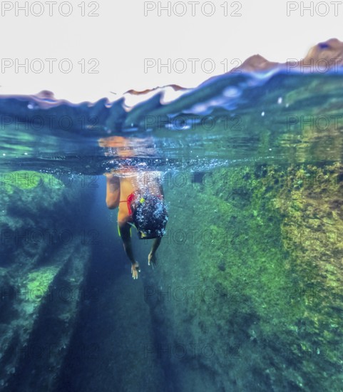 A female swimmer explores the clear natural pools of Tindaya Beach in Fuerteventura, Canary Islands, showing the unspoilt underwater environment