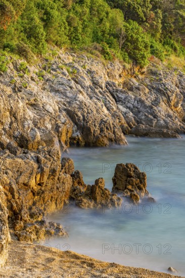 Crystal clear and turquoise water on the beach of Ustrine Bay on a sunny day at sunset on the island of Cres, long exposure, Croatia