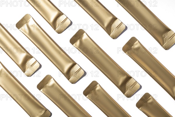 Top view of multiple golden collagen jelly sachets neatly arranged on a white background. These convenient, individually wrapped sachets are ideal for on-the-go collagen supplementation