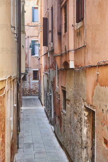 View from a bridge into a small street 'Calle del forno' in Venice on a sunny day in winter, Italy