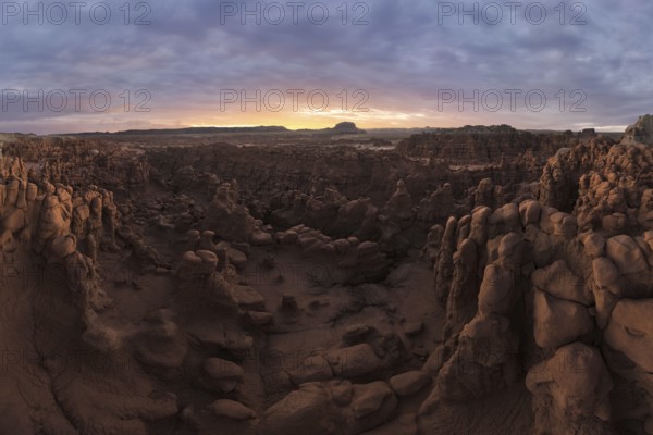 A panoramic aerial photograph capturing the unique rock formations and vast landscape of Goblin Valley State Park, Utah, during sunset