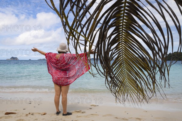 A woman enjoys the breathtaking panorama of the Raja Ampat Archipelago in West Papua, Indonesia The crystal-clear waters and lush landscapes offer a perfect ecotourism experience