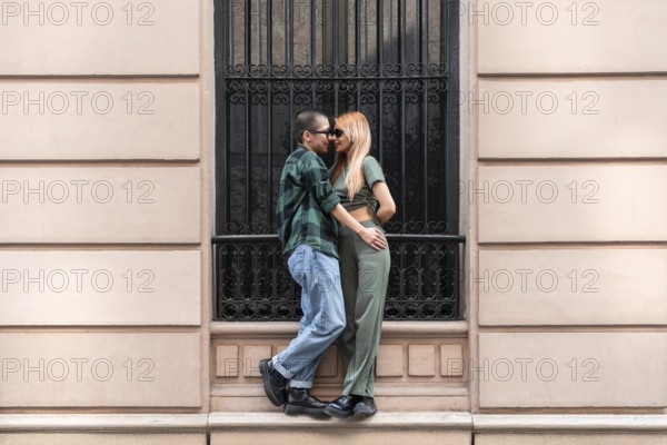 A Colombian lesbian couple stands lovingly in an urban setting, symbolizing pride and identity. Their embrace represents unity and acceptance in the LGBTQIA+ community
