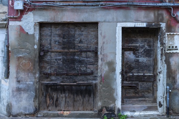 Former grocery store, shop window and entrance door locked with wood, Venice, Veneto, Italy