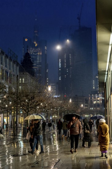 Rainy weather, freezing rain, pedestrian zone Zeil, shopping street, high-rise skyline in clouds, passers-by hurrying through the damp, icy weather, Frankfurt am Main, Hesse, Germany