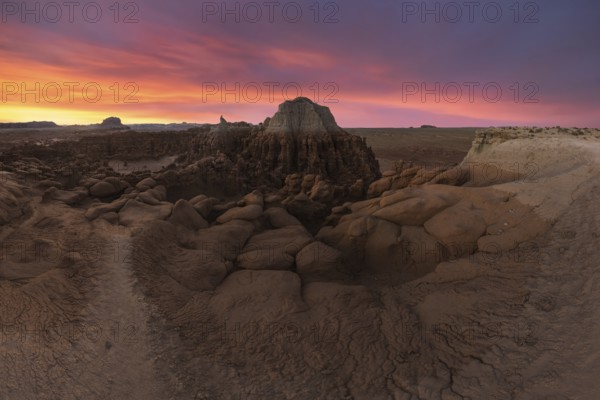 Discover the enchanting Goblin Valley State Park in Utah, where unique sandstone formations create a mystical landscape under a vibrant sunset sky. Perfect for nature and geology enthusiasts