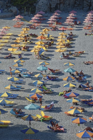 Colourful Ahata beach full of umbrellas and people relaxing and enjoying the sun, Ahata Beach, Aperi, Karpathos, Greece