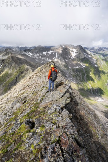 Mountaineer on a steep rocky ridge, on the summit of the Lasörling, Lasörling Group, Hohe Tauern National Park, East Tyrol, Tyrol, Austria