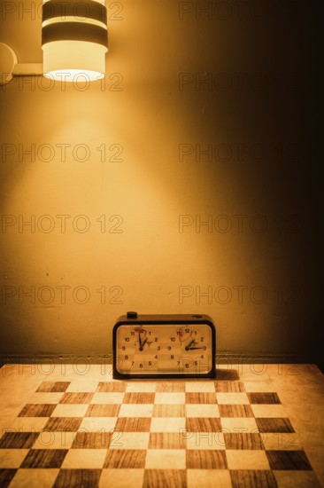 An inviting scene in Swedish Lapland featuring a chessboard and clock bathed in a warm glow from a wall light, creating a serene and cozy ambiance