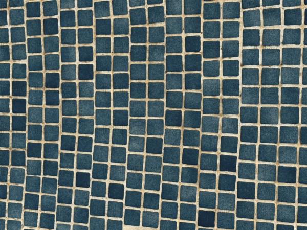 A close-up of a surface adorned with small, blue square tiles arranged in a geometric pattern. The regular grid layout creates a visually appealing modern design