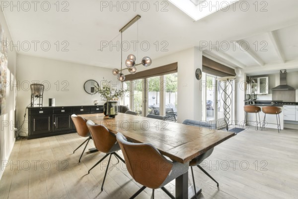 A bright and spacious modern dining room featuring a stylish table, elegant chairs, and large windows that allow natural light to fill the space. Ideal for gatherings