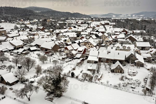Snowy village with characteristic half-timbered houses under grey skies, Herleshausen in northern Hesse