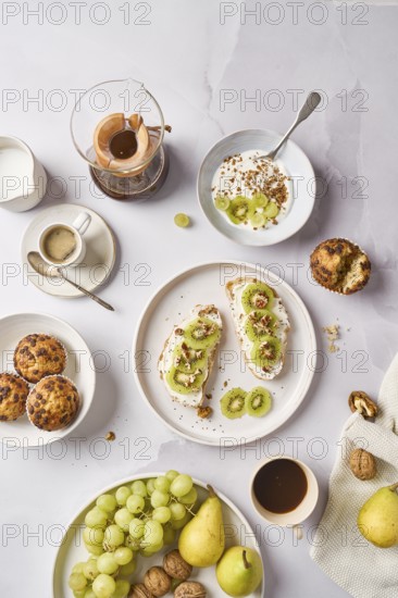 Delicious kiwi toast topped with creamy cheese, crunchy walnuts, and nutritious chia seeds. A perfect blend of flavors and textures for a healthy breakfast with cupcakes, fruits and coffee