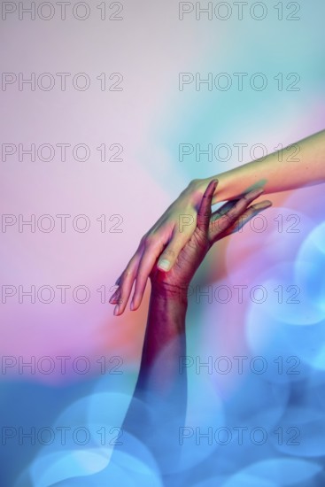 A close-up image of two multiethnic hands reaching towards each other in a gesture of unity and support, set against a vibrant, colorful background symbolizing diversity