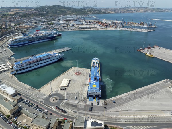 Aerial view of Ancona harbor, Italy, showcasing cruise ships docked at the port, surrounded by urban landscape and the Adriatic Sea