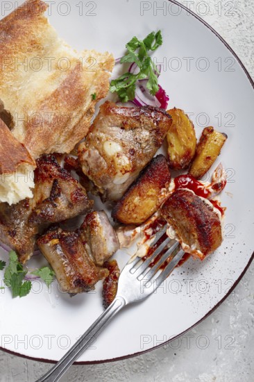 A plate with leftover pork kebab, with bread, on a white plate, close-up, there are no people