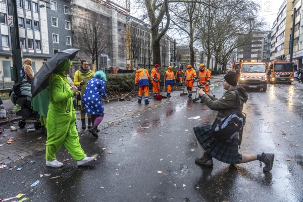 Sweep on Rose Monday in Düsseldorf, the municipal utilities clean up after the train, confetti, camels, trash, employees of AWISTA, Society for Waste Management and City Cleaning, central disposal and urban cleaning companies in Düsseldorf, clean the train's path with their street cleaning machines, North Rhine-Westphalia, Germany