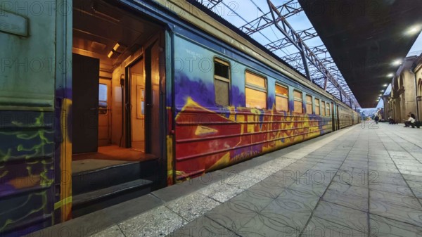 A graffiti-decorated train on the platform at dusk, Yerevan, Armenia