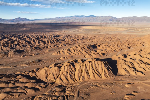 Aerial view of Devil's Desert in Salta, Argentina, revealing intricate eroded formations and colorful sediment layers, forming a stunning natural vista under a vast sky