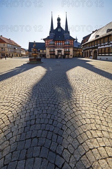 Market square with town hall and long shadow in the backlight, Wernigerode, Harz, Saxony-Anhalt, Germany