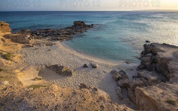 A tranquil beauty of Calo des Mort, Spain, featuring pristine sand and inviting turquoise waters, creating a perfect hideaway for relaxation and scenic enjoyment