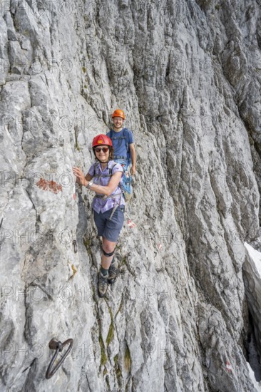 Two mountaineers with helmets climbing on a rock face, ascent to the Ackerlspitze, Wilder Kaiser, Kaiser Mountains, Tyrol, Austria