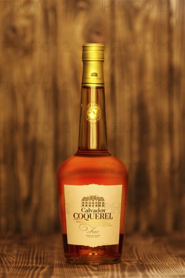 2019, February 23, Minsk, Belarus, Bottle of fine Calvados Coquerel aged in young oak barrels on wooden table