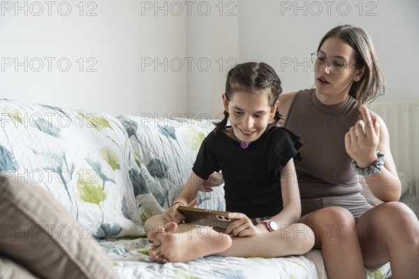A joyful family scene featuring a young cheerful girl with a tracheostomy, sharing a tender moment with her family. The image captures warmth, support, and inclusivity, highlighting the family's bond and care