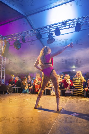 A dancer performs on a colourful stage in front of a celebrating audience, carnival, Schlagerkuchen Donzdorf, district of Göppingen, Germany