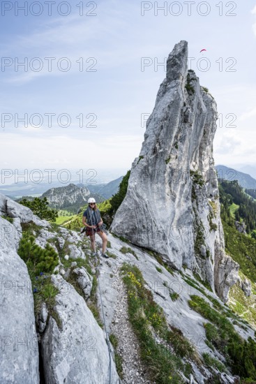 Climber with climbing rope on a climbing tour, climber on a mountain ridge, pointed rock peak, alpine climbing, crossing the Kampenwand, Chiemgau, Bavaria, Germany