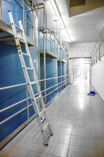 Long corridor with blue walls and a ladder on the side, ENCW Netze Calw waterworks, Calw, Black Forest, Germany