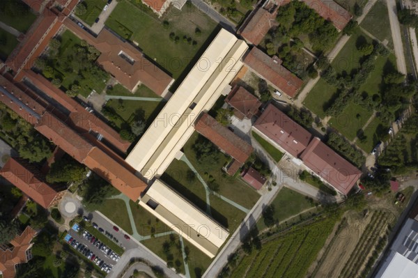 Captivating aerial shot of a hospital showcasing a harmonious blend of modern and historic architecture surrounded by lush green landscapes and pathways, highlighting urban planning and design
