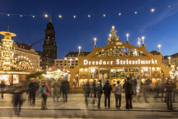 Large walk-in light arch at the entrance to Striezelmarkt, Germany's oldest Christmas market, with the Kreuzkirche tower in the background, Dresden, Saxony, Germany