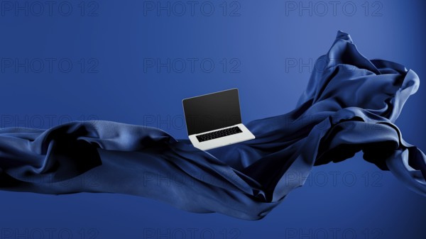 A sleek laptop is placed atop smooth fabric, showcasing its lightweight design against a rich blue backdrop
