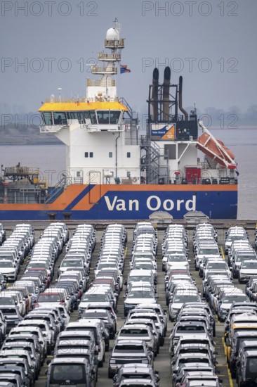 Parking space for import vehicles, hundreds of Hyundai Ioniq, electric cars, waiting for onward transport, behind them, on the Weser, the dredger, the hopper dredger, suction dredger, Vox Ariane, which holds the tug to a certain depth, at the EUROGATE container terminal in the overseas port of Bremerhaven, Lower Saxony, Germany