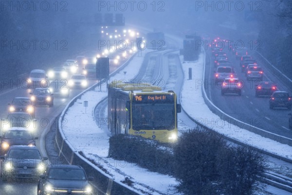 Winter weather, motorway traffic, A40 motorway, Ruhrschnellweg, in Essen, at the Essen-East motorway junction, snowfall, traffic jams, heavy flowing traffic, bus lane between roads, public transport, North Rhine-Westphalia, Germany