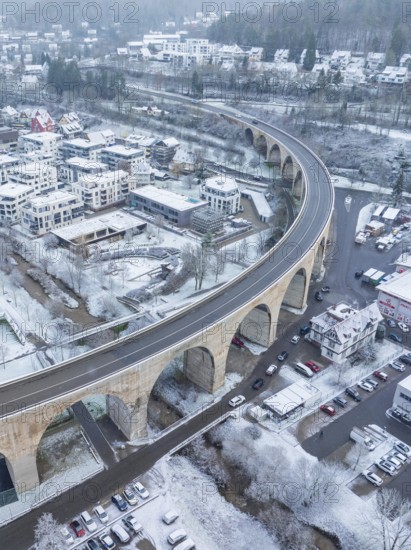 Snowy town with a bridge and cars in a winter landscape seen from the air, Nagold, Black Forest, Germany