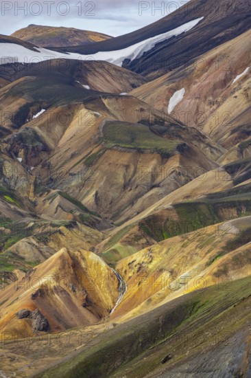 Small river between colourful rhyolite mountains, volcanic landscape, colourful erosion landscape, view from Sudurnamur peak, Landmannalaugar, Fjallabak Nature Reserve, Icelandic Highlands, Suðurland, Iceland