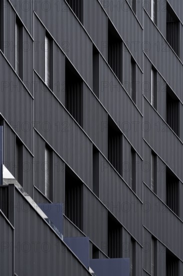 Sustainable modern architecture with building showcasing eco-friendly design elements such as energy efficient structures and low emission materials. The facade's geometry highlights passive house standards contributing to environmental conservation