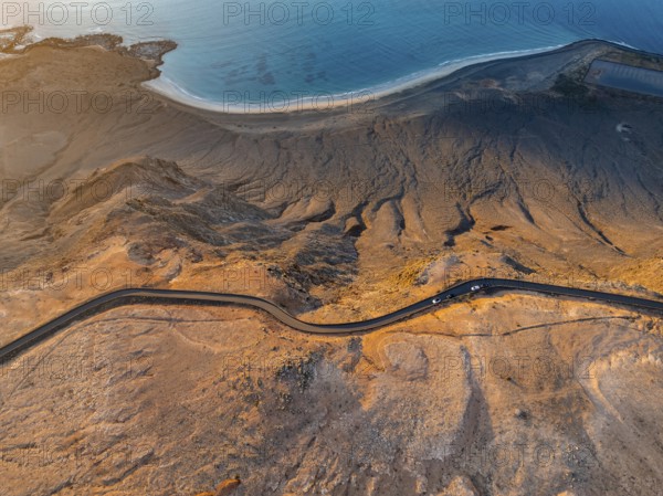 Road on cliffs in evening light, steep cliffs on the coast near Mirador del Porrito, aerial view, top-down, at sunset, Lanzarote, Canary Islands, Spain