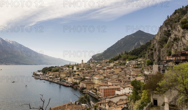 A picturesque view of Limone Sul Garda, Italy, nestled between Lake Garda and steep mountains The charming town features terracotta roofs, a serene waterfront, and lush greenery