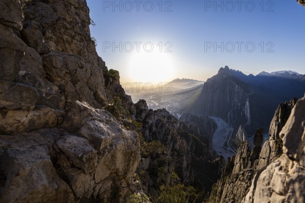 A breathtaking sunrise view from Eagle's Nest in Monterrey, Mexico. The rugged rock formations frame the city skyline and surrounding mountains, creating a picturesque landscape