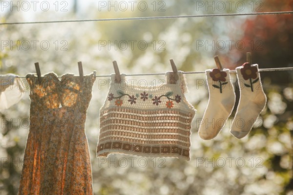 A vibrant scene of freshly washed clothes hanging on a clothesline, basking in warm sunlight. The image captures the essence of simple, sustainable living