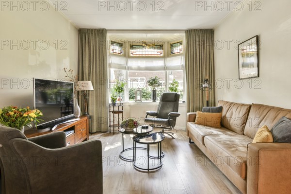 A beautifully arranged living room featuring comfortable furniture, a large window, plants, and soft lighting, creating an inviting atmosphere for relaxation